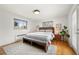 Bright main bedroom with a comfortable bed, bench, wood floors, and modern decor at 2576 Krameria St, Denver, CO 80207