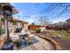 Outdoor patio area with wicker furniture, lush greenery, and a well-maintained brick pathway at 2576 Krameria St, Denver, CO 80207