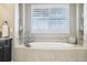 Soaking tub in a serene bathroom with tile surround and a bright window offers a relaxing retreat at 25548 E Fair Dr, Aurora, CO 80016