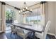 Open dining room featuring hardwood table, stylish lighting fixture, and access to an outdoor patio at 25548 E Fair Dr, Aurora, CO 80016