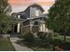 Inviting two-story home with gray siding, brick accents, and manicured landscaping in a desirable neighborhood at sunset at 25548 E Fair Dr, Aurora, CO 80016