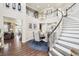 Grand foyer with a stunning curved staircase, elegant chandelier, and hardwood floors throughout at 25548 E Fair Dr, Aurora, CO 80016