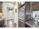 Hallway view to kitchen with stainless steel appliances, dark cabinets and hardwood floors at 25548 E Fair Dr, Aurora, CO 80016