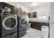Laundry room with side-by-side washer and dryer, dark cabinets, counter space, and utility sink at 25548 E Fair Dr, Aurora, CO 80016