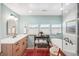 Well-lit bathroom boasting a soaking tub, vanity with sink, stylish fixtures, and multiple windows for natural light at 1455 Flowers Ct, Erie, CO 80516
