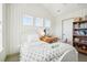 Cozy bedroom with wallpaper, multiple windows, and a built-in bookshelf at 1455 Flowers Ct, Erie, CO 80516