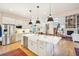 Bright kitchen with stainless steel appliances, white cabinets, and large island with pendant lighting at 1455 Flowers Ct, Erie, CO 80516