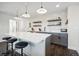 Bright kitchen featuring a large island, stylish pendant lighting, floating shelves, and gray cabinets at 1455 Flowers Ct, Erie, CO 80516
