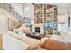 Comfortable living room with floor-to-ceiling bookshelf, fireplace, and large windows at 1455 Flowers Ct, Erie, CO 80516