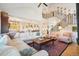 Open living space with view of staircase and gourmet kitchen, beautiful hardwood floors and an area rug at 1455 Flowers Ct, Erie, CO 80516