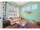 Cozy sitting room with green walls, large windows, and a comfortable sofa at 1455 Flowers Ct, Erie, CO 80516