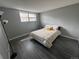 Well-lit bedroom with gray walls, wood-look flooring, a comfortable bed, and a large window at 9440 E Girard Ave # 1, Denver, CO 80231