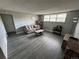 Cozy living room featuring gray walls, wood-look flooring, a comfortable couch, and natural light from the window at 9440 E Girard Ave # 1, Denver, CO 80231