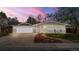 Charming single-story home with a well-manicured lawn, attached garage, and delightful curb appeal at dusk at 712 S Longmont Ave, Lafayette, CO 80026