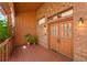 Covered porch entrance with double doors, wood decking, and brick exterior at 6154 Belmont Way, Parker, CO 80134