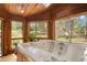 Relaxing hot tub room with wood paneling and expansive windows overlooking a serene, wooded landscape at 6154 Belmont Way, Parker, CO 80134