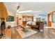 Bright open living room with a fireplace, hardwood floors, and a sky light at 6154 Belmont Way, Parker, CO 80134