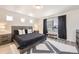 Modern bedroom featuring a gray bed frame, contemporary furniture, and a large window with dark curtains at 10196 Worchester St, Commerce City, CO 80022