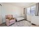 Charming Bedroom with a cozy armchair, a white crib, and a dresser, creating a warm and inviting space at 10196 Worchester St, Commerce City, CO 80022