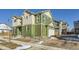 Exterior elevation featuring green siding, brick driveway and two-car garage at 10196 Worchester St, Commerce City, CO 80022