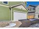 View of attached garage with white door and brick driveway at 10196 Worchester St, Commerce City, CO 80022