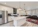 Modern kitchen featuring stainless steel appliances, a large island, and an open layout to the living area at 10196 Worchester St, Commerce City, CO 80022