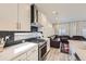 Modern kitchen with stainless steel appliances, dark backsplash, and open layout to the living area at 10196 Worchester St, Commerce City, CO 80022