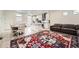 Open-concept living space featuring a modern kitchen, dining area, and comfortable seating with a vibrant, patterned rug at 10196 Worchester St, Commerce City, CO 80022