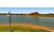 Expansive pond view with a grassy shoreline and community buildings visible in the distance at 10196 Worchester St, Commerce City, CO 80022