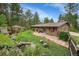 Lush backyard featuring a charming gazebo, serene waterfall, and stone patio, perfect for outdoor relaxation and entertaining at 29832 Dorothy Rd, Evergreen, CO 80439