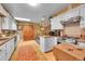 Well-lit kitchen with white cabinets, stainless steel appliances, and hardwood floors at 29832 Dorothy Rd, Evergreen, CO 80439