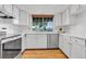 Bright kitchen features white cabinetry, stainless steel appliances, and a window overlooking the neighborhood at 3807 Paseo Del Prado, Boulder, CO 80301