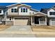 Charming two-story home featuring a two-car garage, covered porch, and stone accents on the facade at 25313 E Warren Pl, Aurora, CO 80018