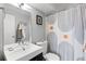 Clean bathroom with modern vanity, neutral walls, framed art, and patterned shower curtain at 1090 N Lafayette St # 503, Denver, CO 80218