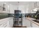 Updated kitchen features stainless steel appliances, white cabinets, and modern backsplash at 1090 N Lafayette St # 503, Denver, CO 80218