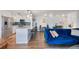 Living room and kitchen featuring a blue sofa, kitchen island with marble countertop and stainless steel appliances at 1090 N Lafayette St # 503, Denver, CO 80218