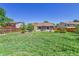 Large backyard featuring a combination of natural grass and artificial turf, bordered by mature trees and wood fencing at 18874 E Colorado Dr, Aurora, CO 80017