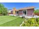 Landscaped backyard with well-maintained artificial turf, a patio with outdoor seating, and mature trees at 18874 E Colorado Dr, Aurora, CO 80017