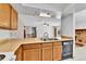 Open kitchen with wooden cabinets, stainless steel sink, and a view into the living area at 18874 E Colorado Dr, Aurora, CO 80017