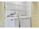 A functional laundry room with modern washer and dryer units, complemented by convenient overhead wire shelving at 18874 E Colorado Dr, Aurora, CO 80017