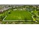Aerial view of a community featuring a large green space with soccer fields, playgrounds, and walking paths at 23421 E Rockinghorse Pkwy, Aurora, CO 80016