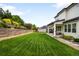 Expansive backyard with lush green lawn, a patio area, and tiered landscaping at 23421 E Rockinghorse Pkwy, Aurora, CO 80016