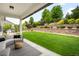 Backyard view with a cozy patio area, lush green lawn, and tiered landscaping for added privacy at 23421 E Rockinghorse Pkwy, Aurora, CO 80016