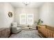 A cozy Bedroom with hardwood floors, a crib, a rocking chair and large windows offering ample natural light at 23421 E Rockinghorse Pkwy, Aurora, CO 80016