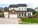 Charming two-story home featuring a manicured lawn, stone accents, and a three-car garage at 23421 E Rockinghorse Pkwy, Aurora, CO 80016