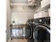 Well-organized laundry room with storage, folding table, and front-loading washer and dryer at 23421 E Rockinghorse Pkwy, Aurora, CO 80016