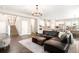 Open-concept living room with hardwood floors, a cozy sofa, and access to the kitchen and stairs at 23421 E Rockinghorse Pkwy, Aurora, CO 80016
