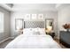 Bright main bedroom with a tufted headboard, accent mirrors, a dresser, and plush bedding at 23421 E Rockinghorse Pkwy, Aurora, CO 80016