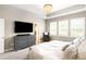Comfortable main bedroom featuring hardwood floors, a large dresser, a tray ceiling, and ample light from windows at 23421 E Rockinghorse Pkwy, Aurora, CO 80016
