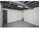 Partially finished basement with painted floor and an open door, offering possibilities for recreation and storage at 1809 W Crestline Dr, Littleton, CO 80120